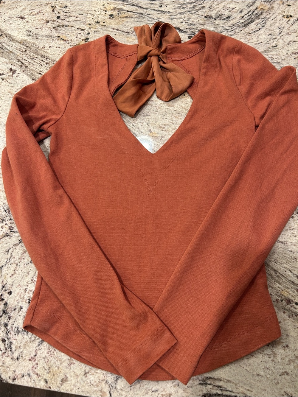 Women's pumpkin color Free People XS long-Sleeve V-Neck Top with Back Tie.